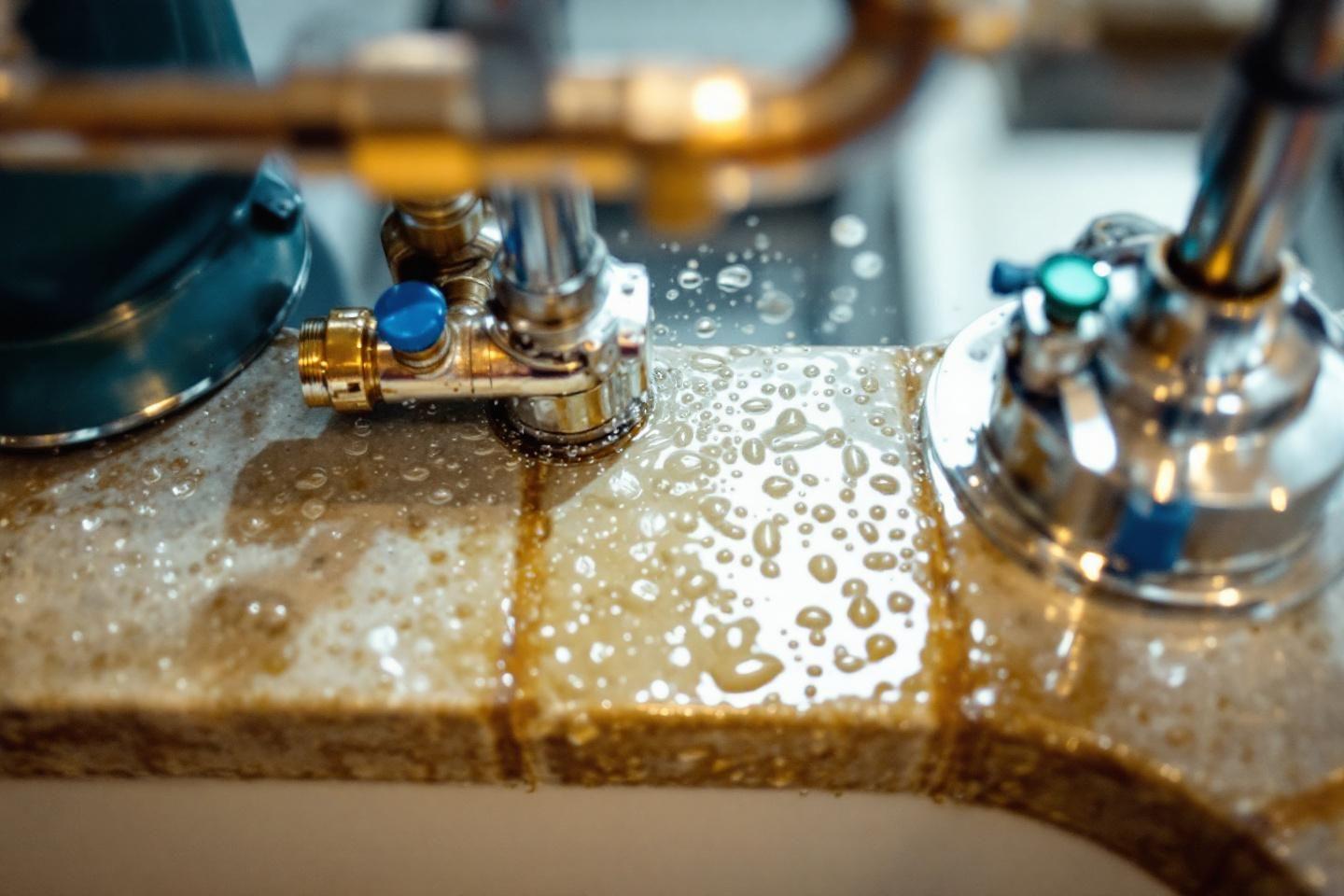 Gros plan de robinet avec écoulement et gouttes d'eau