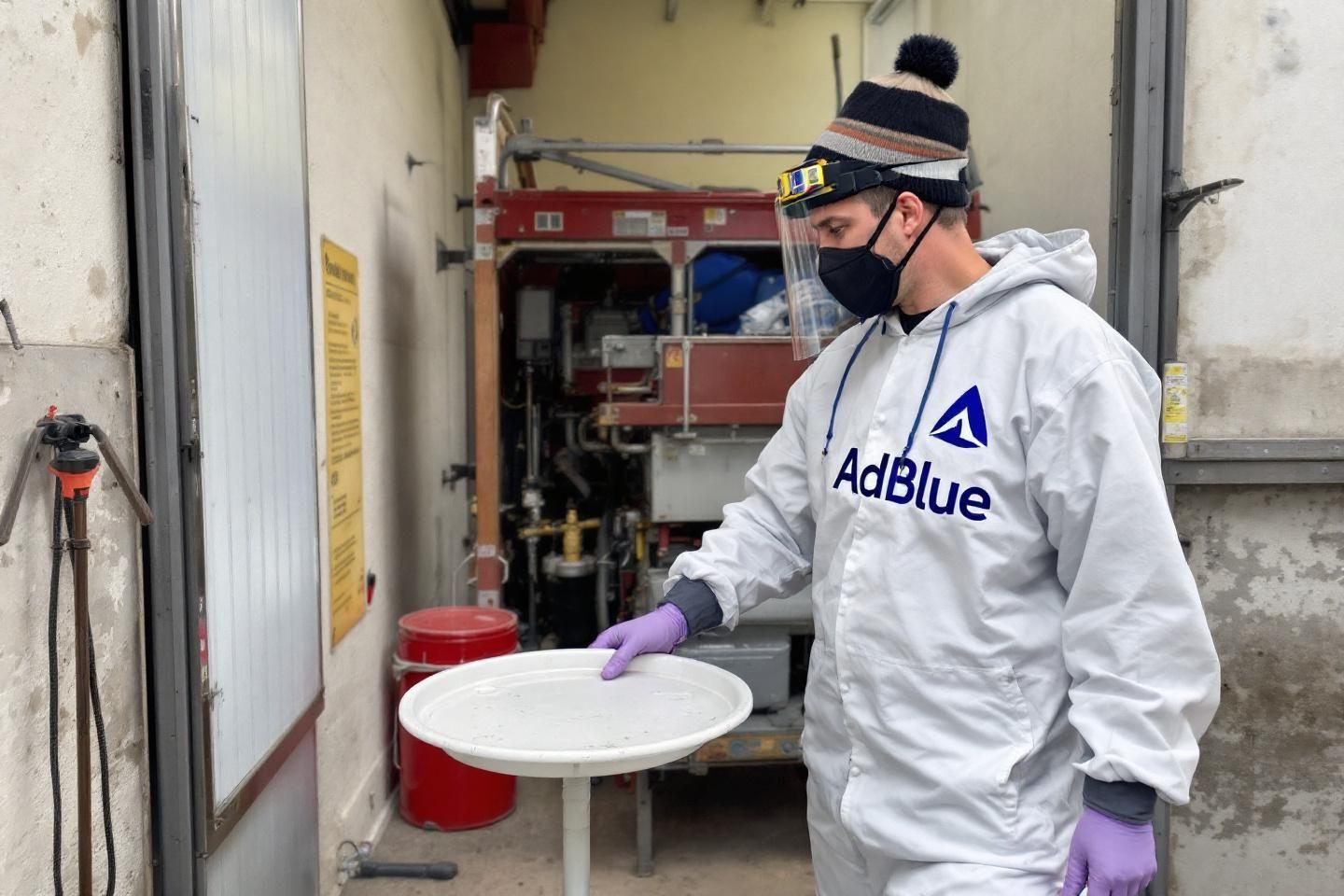 Employé portant un masque et des gants travaillant dans un local technique